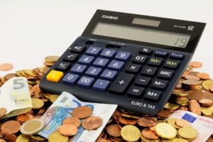 A calculator on top of a money pile, save money buying a home in Clarksville TN