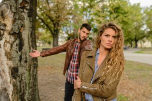 A young couple having an argument in the park, something that happens often when buying a house together with your spouse for the first time