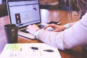 A person doing online research in order to buy a house remotely.