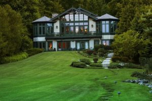 An isolated luxury home surrounded by trees and a freshly mowed lawn.